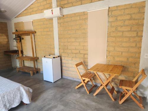 a room with a table and chairs and a refrigerator at Chalés Mirante da Lua Chalé 2 in Cavalcante