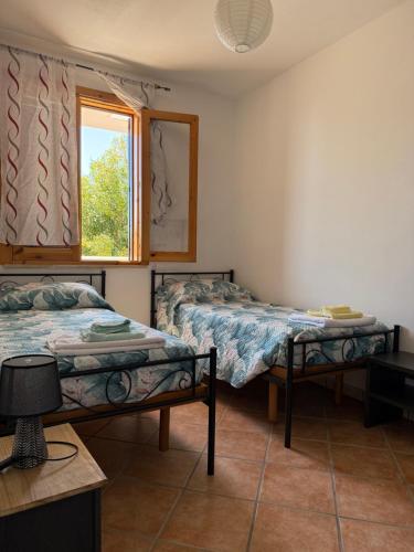 a bedroom with two beds and a window at VILLA ENA in Torre dell'Orso