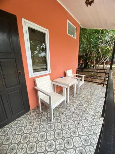 a patio with two chairs and a table and a door at Park & Pool Resort in Nong Khai