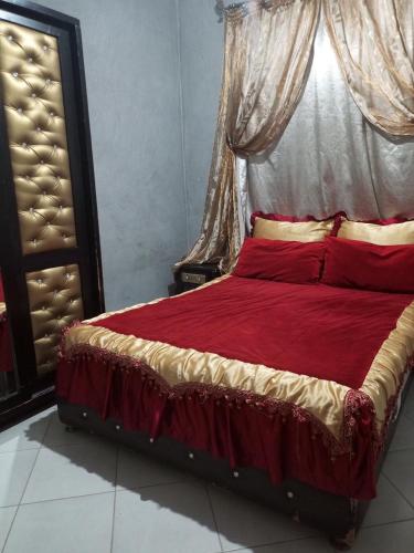 a bedroom with a large bed with red pillows at شقة جميلة و هادئة in Agadir