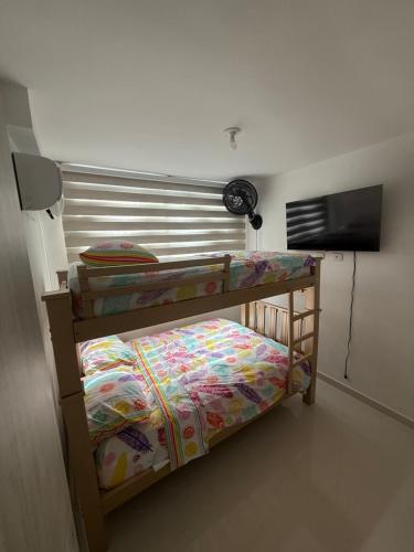 a bedroom with two bunk beds and a fan at Apartamento norte de Barranquilla in Barranquilla