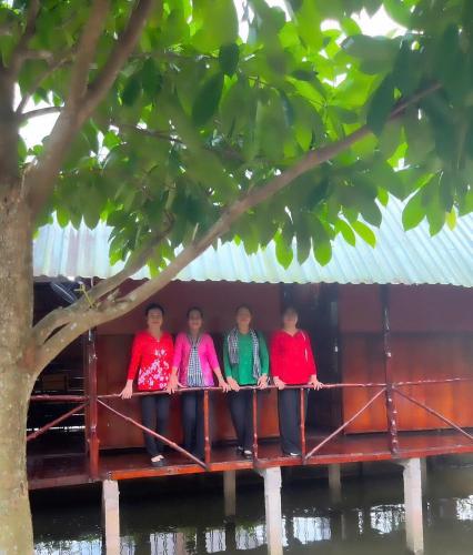 a group of four people sitting on a bridge at Ba Hung homestay in Ấp Hòa Phú (2)