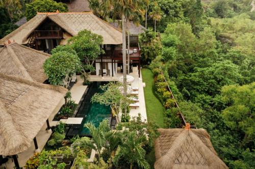 an aerial view of a resort with a pool and trees at Jimbaran Beach Villas by Nakula in Jimbaran
