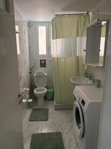 a bathroom with a toilet and a sink and a washing machine at SMYRNA HOMES CHiOS ERATO in Chios
