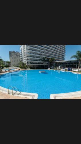 a large blue swimming pool with a pair of glasses at Apartamento El Eden in Playa de Gandia