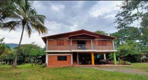 a house with a balcony and a palm tree at Finca La Macarena in Estación El Salto
