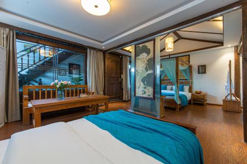 a bedroom with a bed and a desk in a room at Yueju Designer Homestay in Lijiang