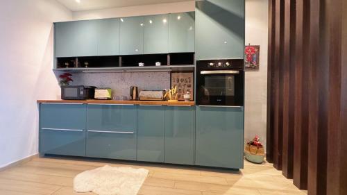 a kitchen with blue cabinets and a stove at Bangi Avenue Charming 4BR Blissful Holiday Homestay in Kajang