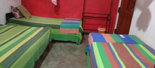 two beds in a room with green and colorful at Beni Beach Resort Batticaloa, Sri Lanka in Kallady