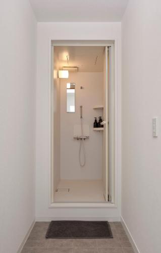 a bathroom with a shower with a glass door at Pension Sora in Nachikatsuura