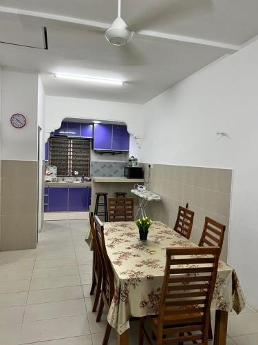 a dining room with a table and a kitchen at Dlaili Homestay in Tanjung Karang