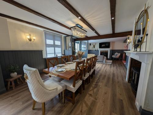 a dining room with a table and chairs and a fireplace at A historic Pub with a modern twist - The Greyhound in Bury Saint Edmunds