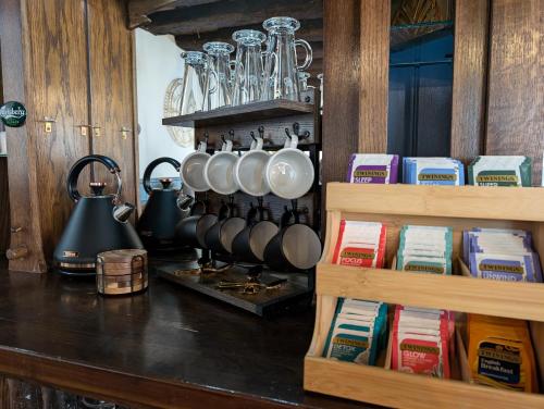 a kitchen counter with pots and pans and books at A historic Pub with a modern twist - The Greyhound in Bury Saint Edmunds