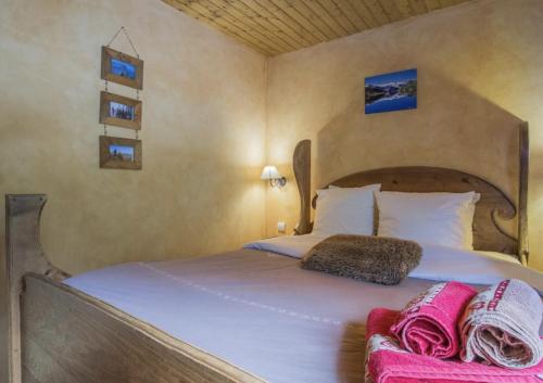 a bedroom with a bed with white sheets and pink blankets at Chalet le Névé in Bonneval-sur-Arc