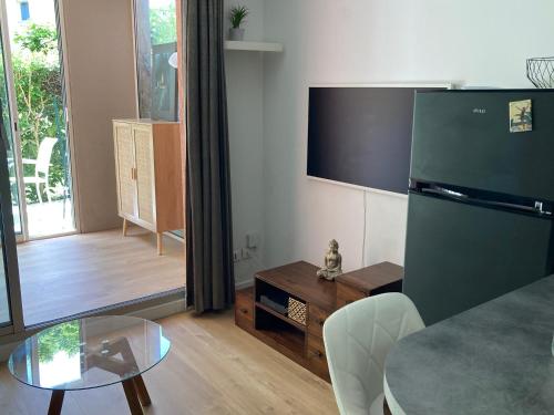 - un salon avec une table en verre et un réfrigérateur dans l'établissement Zen Attitude Apartment, à Cagnes-sur-Mer