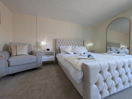 a bedroom with a large white bed and a chair at A historic Pub with a modern twist - The Greyhound in Bury Saint Edmunds