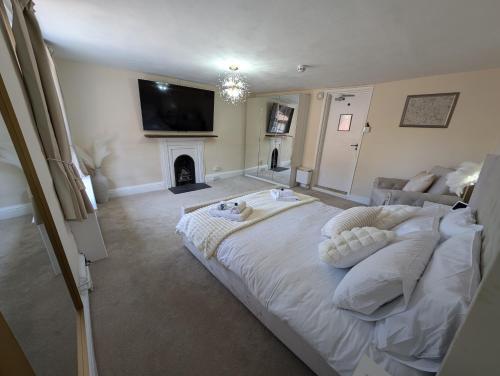 a bedroom with a large bed and a fireplace at A historic Pub with a modern twist - The Greyhound in Bury Saint Edmunds