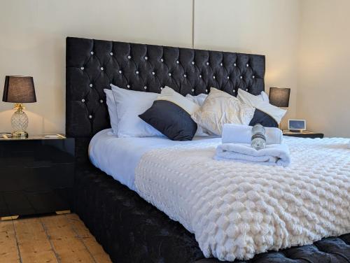 a bedroom with a large bed with a black headboard at A historic Pub with a modern twist - The Greyhound in Bury Saint Edmunds