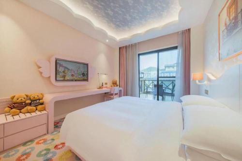 a bedroom with a large white bed and a window at Deefly Yinrun Town Hotel in Deqing