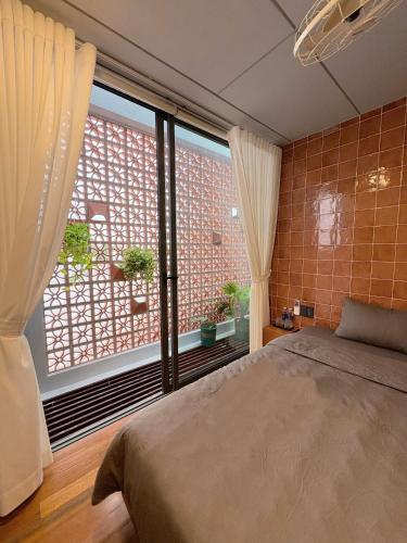 a bedroom with a bed and a large window at Local Charm Homestay in Thôn Trường Giang