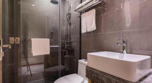 a bathroom with a sink and a toilet and a shower at VX Hotel Xiamen Siming District Xiamen University Huandao Road in Xiamen