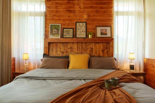 a bedroom with a large bed with two windows at Tranquil House Manali in Haripūr