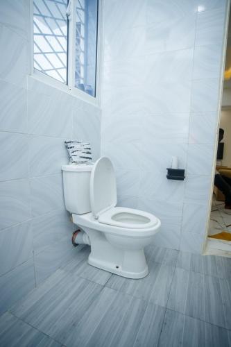 a white toilet in a bathroom with a window at Clarah's paradise in Mombasa