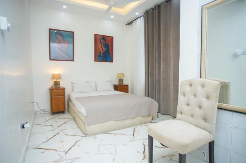 ein Schlafzimmer mit einem Bett und einem Stuhl in der Unterkunft Clarah's paradise in Mombasa