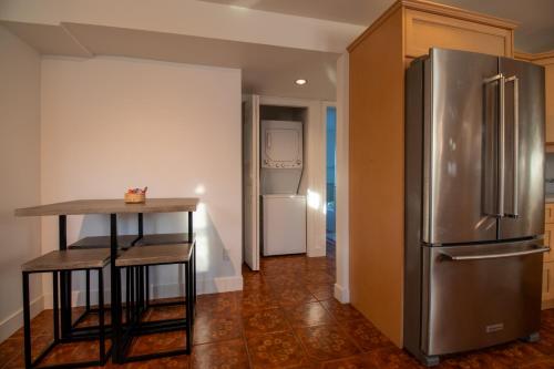 a kitchen with a stainless steel refrigerator and a table at Serene Garden Suite in Delta