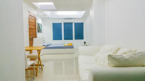 a living room with a couch and a table at Studio in townhouse with private bath room and kitchenette in Amphoe Phra Khanong