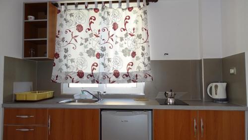 a kitchen with a sink and a curtain over a window at Apartments Neri in Ksamil