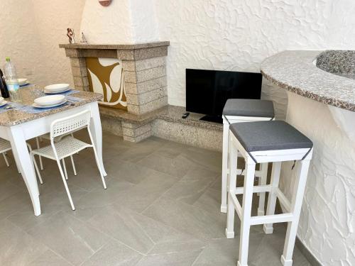 a living room with a table and chairs and a fireplace at 100 m to the sea with air conditioning and speed WiFi in Marina di Sorso