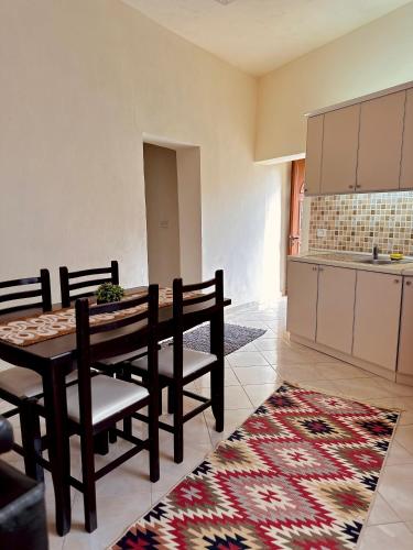a kitchen and dining room with a table and chairs at Domus Komanesse - Guest Houses in Koman