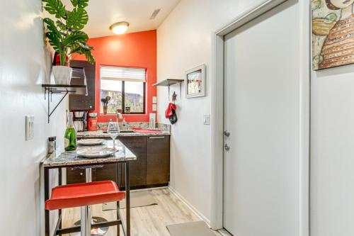 a kitchen with orange walls and a counter with a red stool at Wellness Hiker's Haven in Sedona
