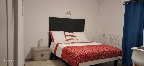 une chambre avec un lit avec une couverture rouge dans l'établissement Opulence Pau, à Pau