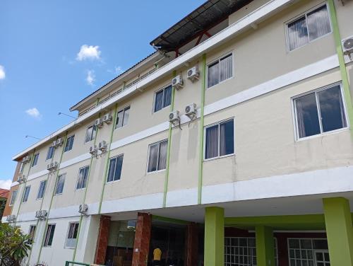 a large white building with green columns at Graha Laweyan Solo in Bonorejo