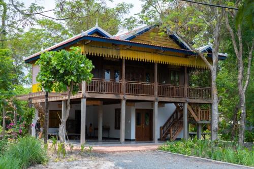 a house in the woods with a balcony at Beng Mealea Lodge in Phumĭ Trach Pôk (2)