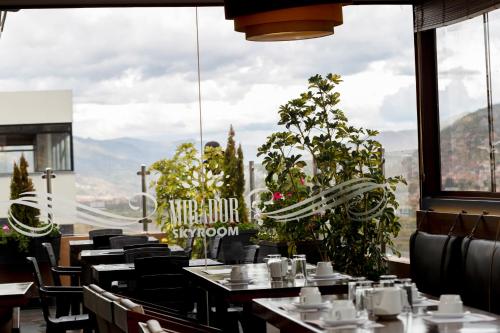 a restaurant with tables and chairs and a large window at Hotel Sky Mirador in Cusco