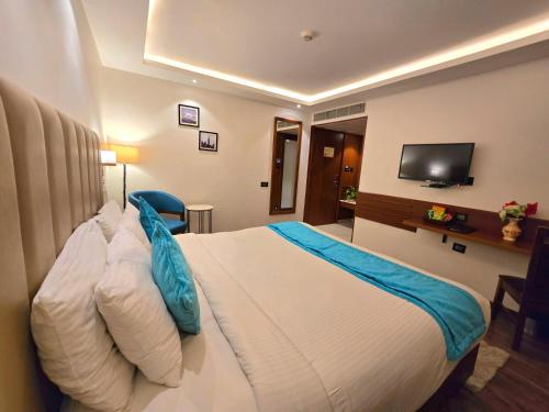 a hotel room with a bed and a flat screen tv at Ayra Boutique Hotel in Bengaluru