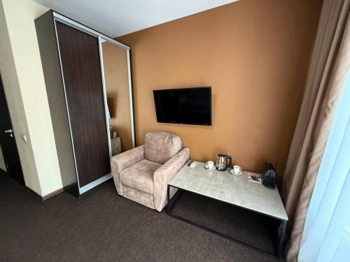 a hotel room with a chair and a television at EVEREST Готель in Poltava