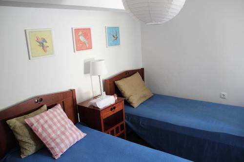 a bedroom with two beds and a night stand with a lamp at Chios Stone House in Chios