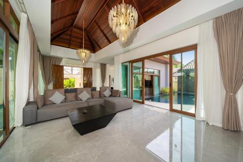 a living room with a couch and a table at Ocean Palms Private Pool Villas in Ban Thalat Choeng Thale