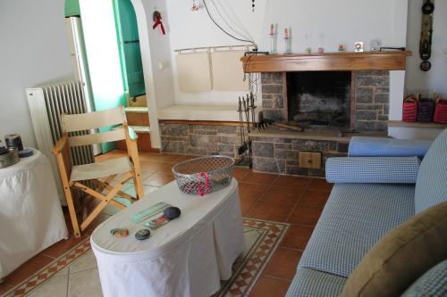 a living room with a table and a fireplace at Chios Stone House in Chios