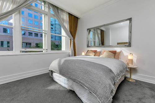 ein Schlafzimmer mit einem Bett und einem großen Fenster in der Unterkunft Stylish Retreat with city views in Auckland CBD in Auckland
