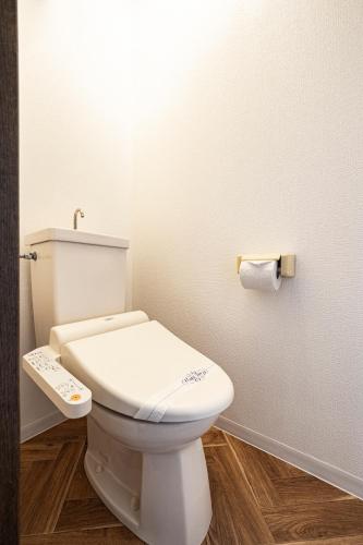 a bathroom with a white toilet and a roll of toilet paper at HITO 藤崎 Fujisaki in Fukuoka