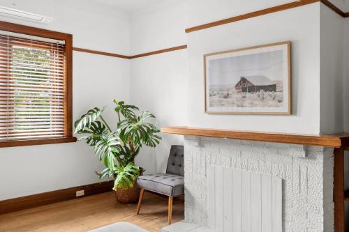 - un salon avec une cheminée et une chaise dans l'établissement Charming 1930s Cottage Retreat I Pet Friendly Escape, à Geelong West