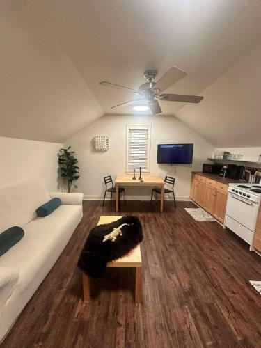 a living room with a couch and a ceiling fan at Trendy-attic at rice village in Houston