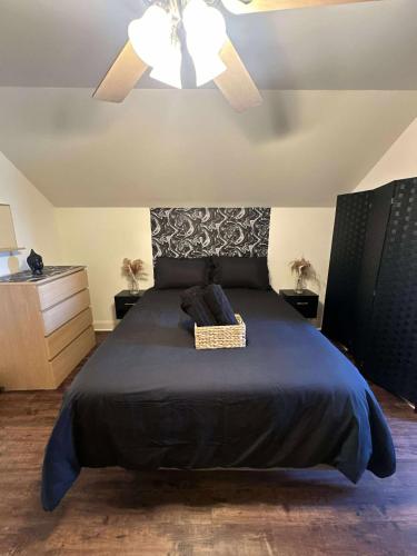 a bedroom with a large bed with a ceiling fan at Trendy-attic at rice village in Houston