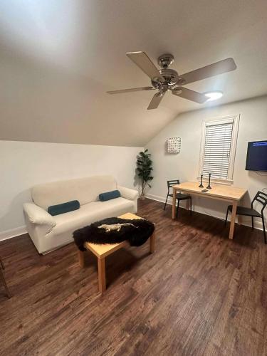 a living room with a couch and a ceiling fan at Trendy-attic at rice village in Houston