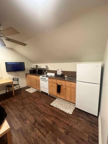 a kitchen with a white refrigerator and wooden cabinets at Trendy-attic at rice village in Houston